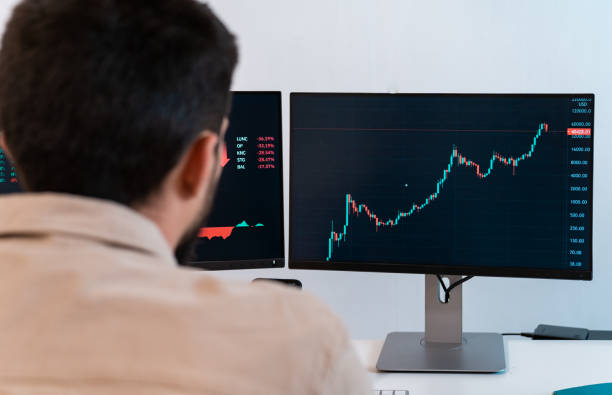 istock Young caucasian male finance broker analyzing stock graphs while trading from modern home office. 1450322643