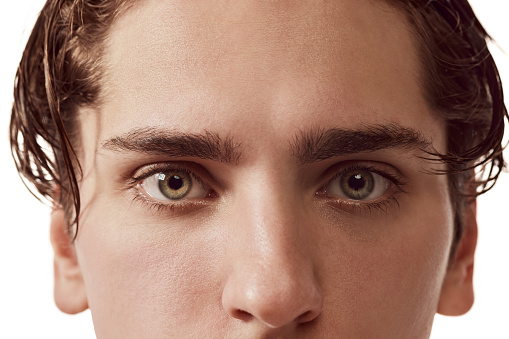 Close-up image of male green eyes of young man isolated over white background. Concept of vision, healthcare, medicine, men's beauty, care. Attentive look. Copy space for ad