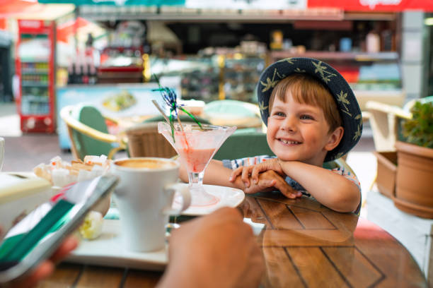 istock Cute little boy eats ice-cream in a cafe 1450324079