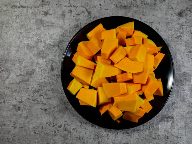 istock butternut squash slice in wooden bowl isolated on white background with clipping path. Top view with copy space for your text. Flat lay 1450324166