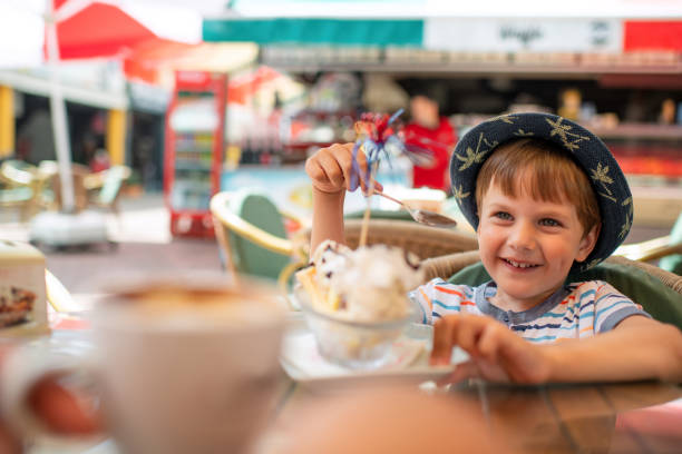 istock Cute little boy eats ice-cream in a cafe 1450324267