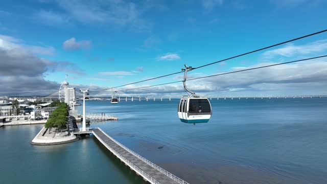 Telecabine Lisboa at Park of Nations (Parque das Nacoes). Cable car in the modern district of Lisbon over the Tagus river on a Summer day. 4k