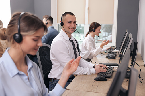 Call center operators with headsets working in modern office