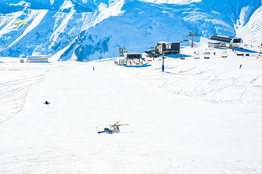 View from the top of a mountain, with skiers and restorant in a distance, France, La Plagne