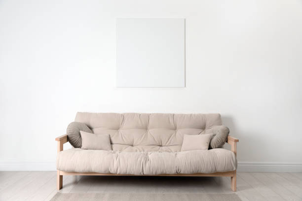 istock Blank canvas on wall over beige sofa indoors. Space for design 1450324686