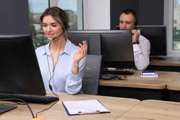 istock Call center operators with headsets working in modern office 1450324887