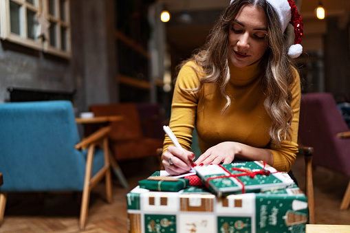 Young beautiful woman packing presents for Christmas
