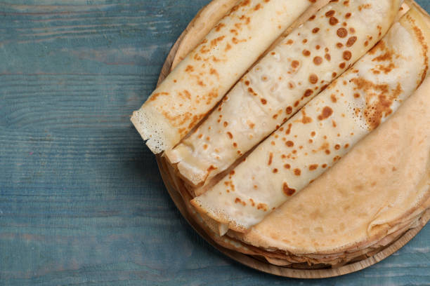 istock Delicious crepes on blue wooden table, top view. Space for text 1450325493