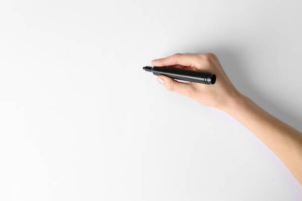 Woman holding black marker on white background, top view. Space for text