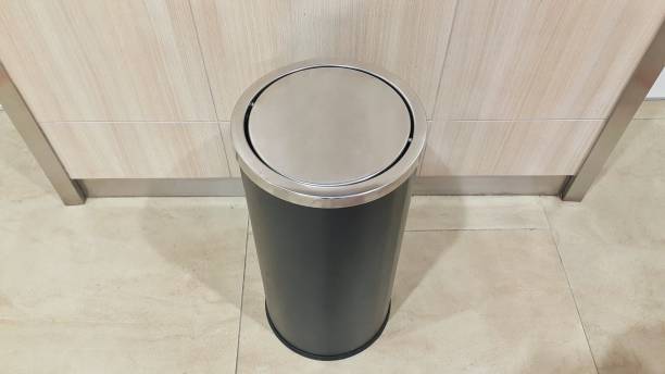 istock Black round metal trash bin on the floor 1450326706