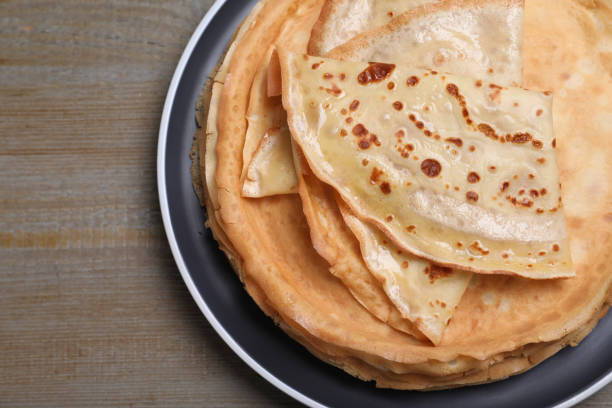 istock Stack of delicious crepes on grey wooden table, top view 1450327007