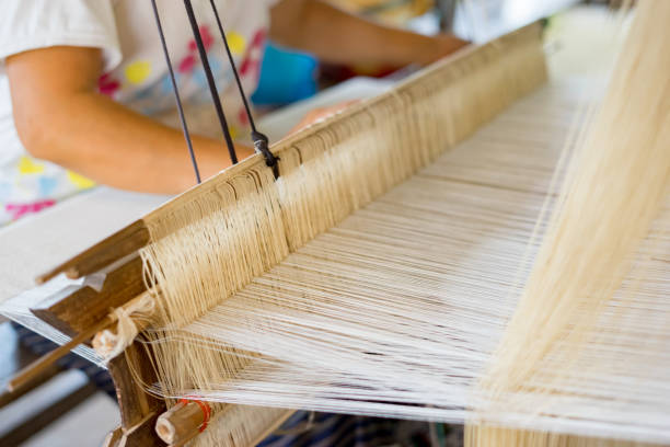 weave silk cotton on the manual wood loom in laos ,thailand,selective focus,vintage color stock photo