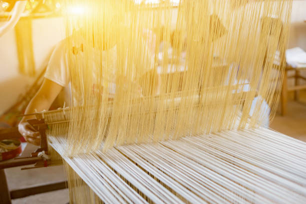 weave silk cotton on the manual wood loom in laos ,thailand,selective focus,vintage color weave silk cotton on the manual wood loom in laos ,thailand,selective focus,vintage color carpet factory stock pictures, royalty-free photos & images