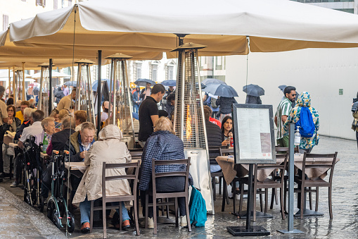 People eating at Sidewalk Cafe at Piazza del Duomo in Florence in Tuscany, Italy