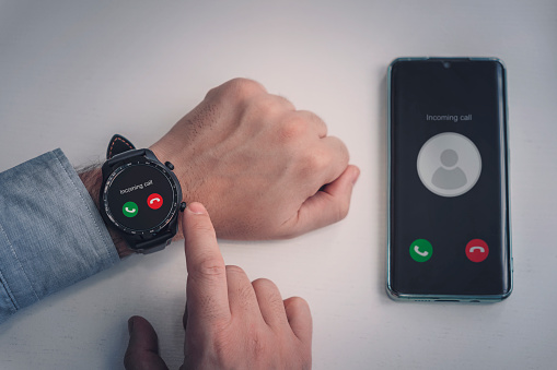 incoming call on a modern smart watch. black smart watch and a smartphone on a white background. Wireless connection of a modern watch with a smartphone
