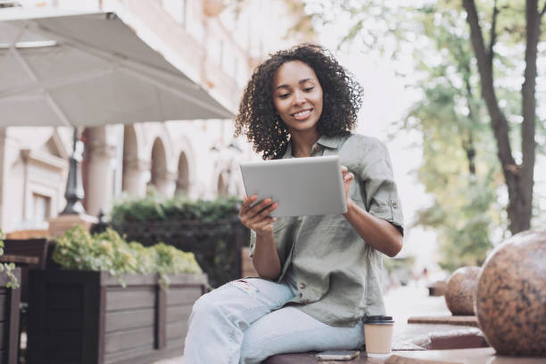 istock Happy woman using digital tablet in a city 1450327918