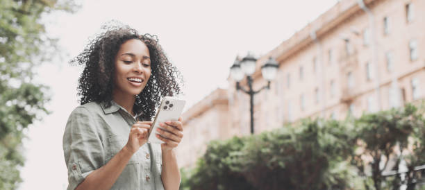 istock Happy woman using smart phone in a city, panoramic banner 1450328463