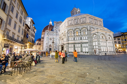 People at a sidewalk cafe on Piazza del Duomo near Baptistery of St John on Piazza San Giovanni of Florence in Tuscany, Italy