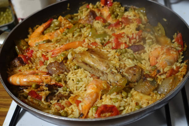 Seafood paella with lamb meat and chicken being cooked