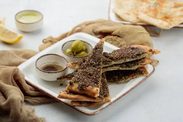 Manakish Zaatar Cheese pizza slice with lime and olive served in dish isolated on table top view of arabian food