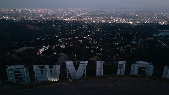 Los Angeles, United States – June 15, 2022: A cityscape nighttime view of LA from behind the Hollywood sign