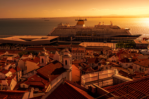 Lisbon, Portugal - November 01, 2022: aerial view over the rooftops of Lisbon. In background is Tagus River with a cruise ship