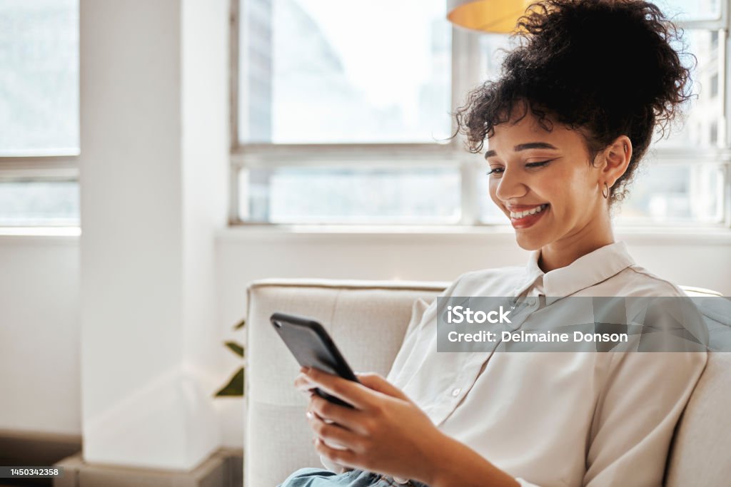 Phone, relax and woman on social media for happy online content or internet entertainment on house sofa. Smile, digital or young girl enjoys texting, chat or typing a post while reading global news Subscription Stock Photo