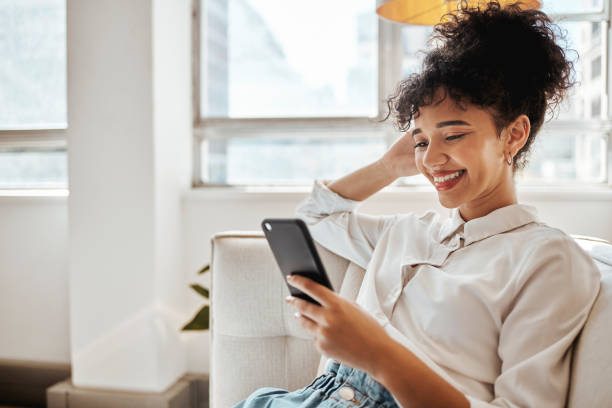 istock Smartphone, sofa and happy black woman or student with email feedback for online course results, website information search or social media post. Smile, youth and gen z girl using phone on home couch 1450342365