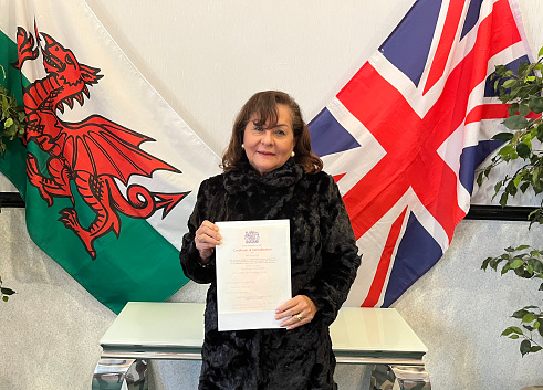 Senior Hispanic woman with British Naturalization certificate
