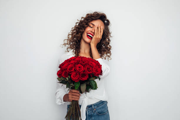 Beautiful emotional woman holding bouquet of flowers stock photo