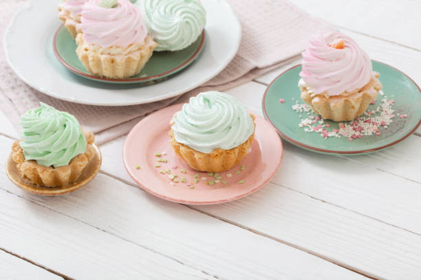 istock cupcakes on plates on white wooden background 1450344959