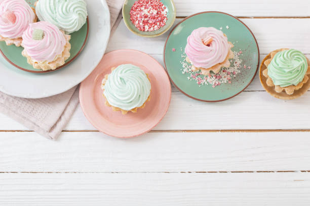 istock cupcakes on plates on white wooden background 1450345026