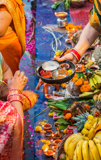 istock devotee praying with religious offerings for sun god in Chhath festival 1450345733