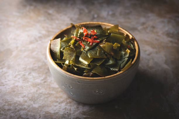 ensalada con kombu de algas, pimientos rojos picantes y salsa de soja. las algas marinas son una de las tendencias alimentarias de 2023, vista frontal - wakame salad fotografías e imágenes de stock