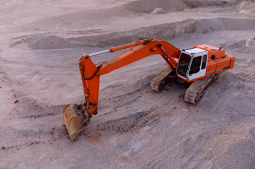 Excavator machine working in a quarry seen from above