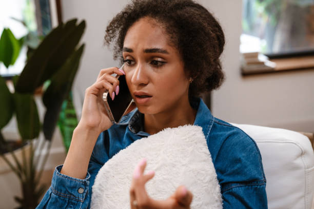 istock Young woman while holding pregnancy test and talking on cellphone 1450354636