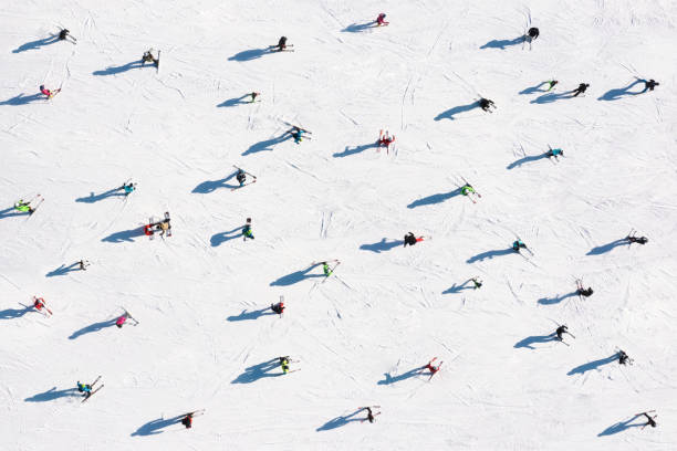 station de ski. vue aérienne des skieurs et snowboarders. sports d’hiver. - aerial view landscape scenics snow photos et images de collection