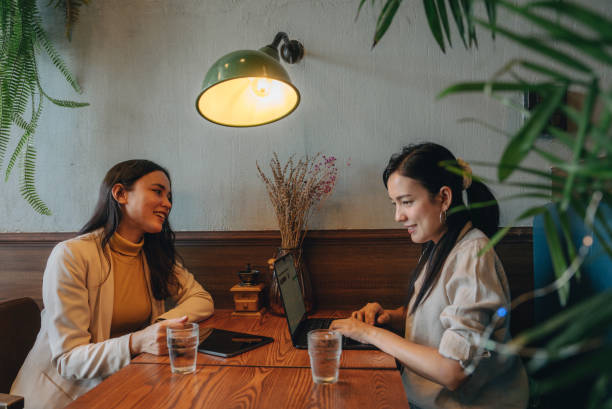istock Two young women are presenting a project while eating together. 1450356457