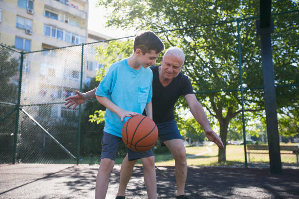 istock Happy grandfather and grandson practicing basketball 1450358294