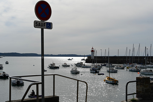 Erquy, France, September 22, 2022 - Erquy harbor and lighthouse in backlight.