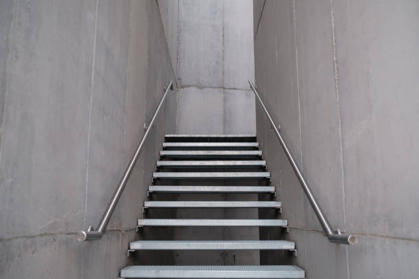 istock Long metal stair in modern concrete office building. 1450365869