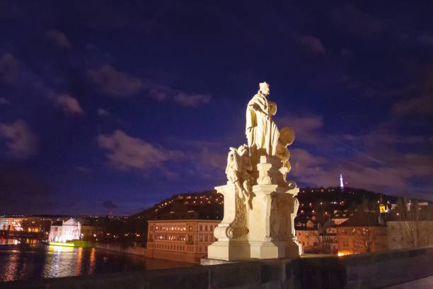 Early morning atmosphere of the famous Charles Bridge in Prague with the gas lamps lit.