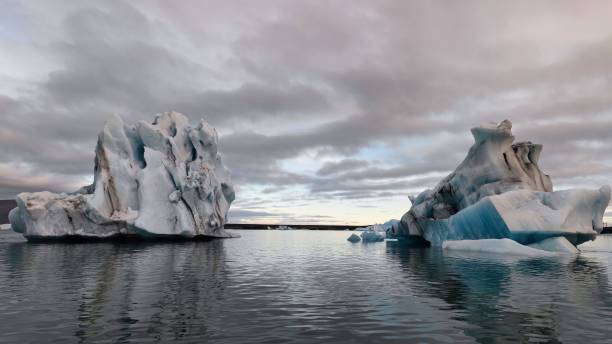 istock Floating icebergs in the water against a cloudy sky 1450368345