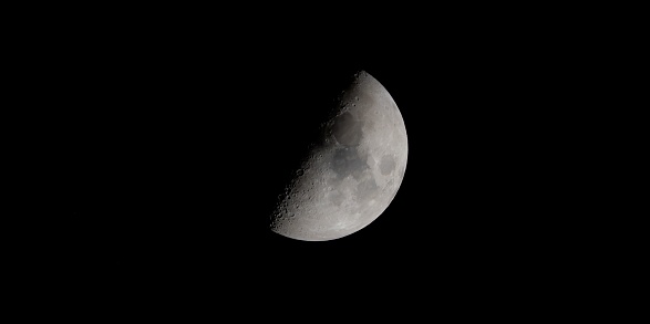 A beautiful shot of the half moon isolated on a dark night sky