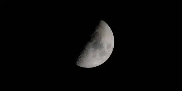 A beautiful shot of the half moon isolated on a dark night sky