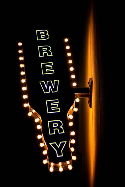 istock Lit brewery sign attached to a wall isolated on a dark background 1450368377