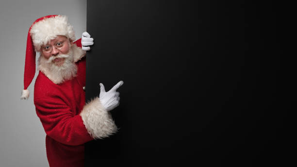 istock Santa Claus pointing black billboard 1450368460