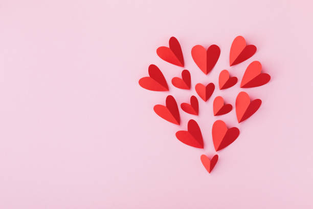 istock Valentines day pattern from red paper hearts on pink table. Greeting holiday composition. 1450370053