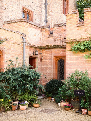 Oxburgh, United Kingdom – August 07, 2022: A vertical shot of plants outside the red brick private entrance to Oxburgh Hall, Norfolk, UK