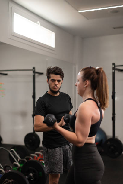 istock A male coach guiding his female trainee with her posture 1450373226